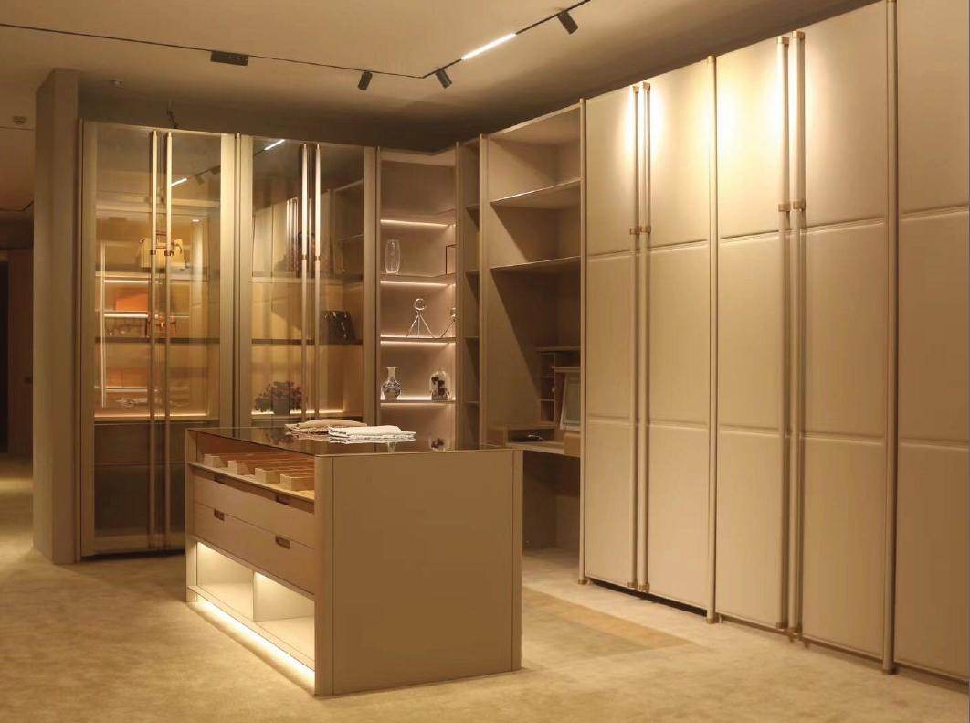 Walk-in wardrobe with leather-panel doors, glass display cabinets and a central island